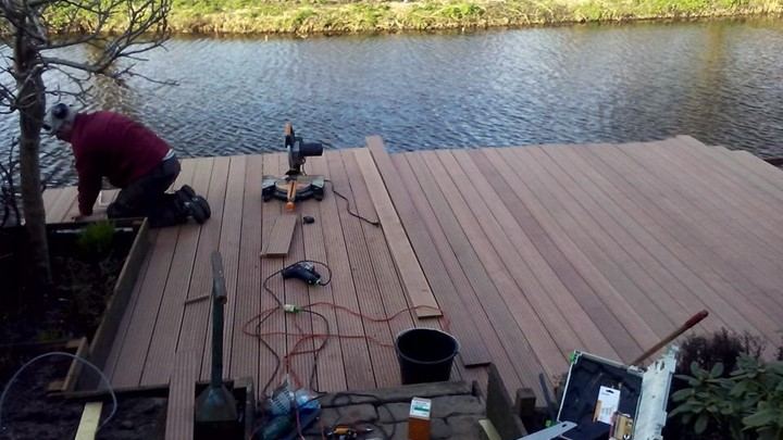 Terras van hardhouten vlonderdelen langs het water